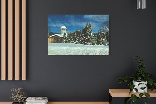 Framed winter landscape print on a dark wall with wooden shelves and decor.